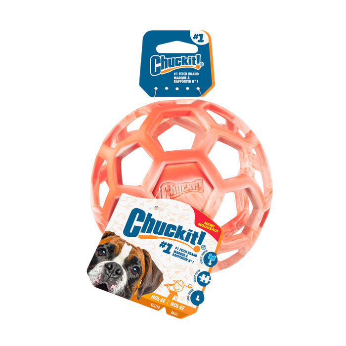 An orange Chuckit! Hol-ee Roller interactive dog toy ball in packaging displays a dog photo, Chuckit! brand logo, and product info with icons showing fetch, tug, and treat-stuffing play.