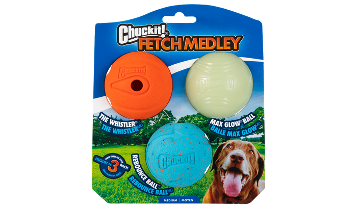 The Chuckit! Medium Fetch Medley Dog Ball Set by Chuckit! features three balls—Whistler (orange), Rebound (blue), and a glow-in-the-dark ball—on a blue and green backdrop with a happy dog in the bottom right corner.