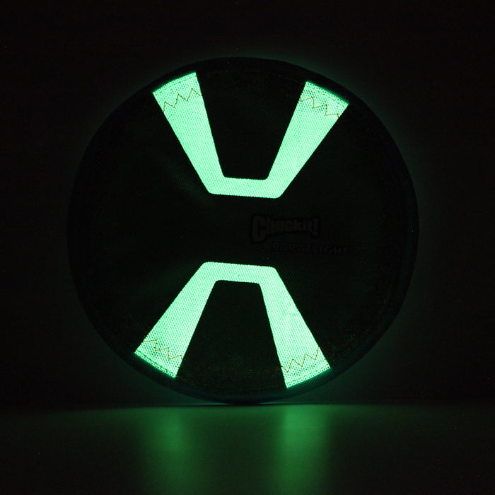 The Chuckit! Paraflight Max Glow Flyer Dog Toy by Chuckit! is a circular glowing toy that resembles a futuristic device with its bright green accents, standing out against dark backgrounds for nighttime fetch.