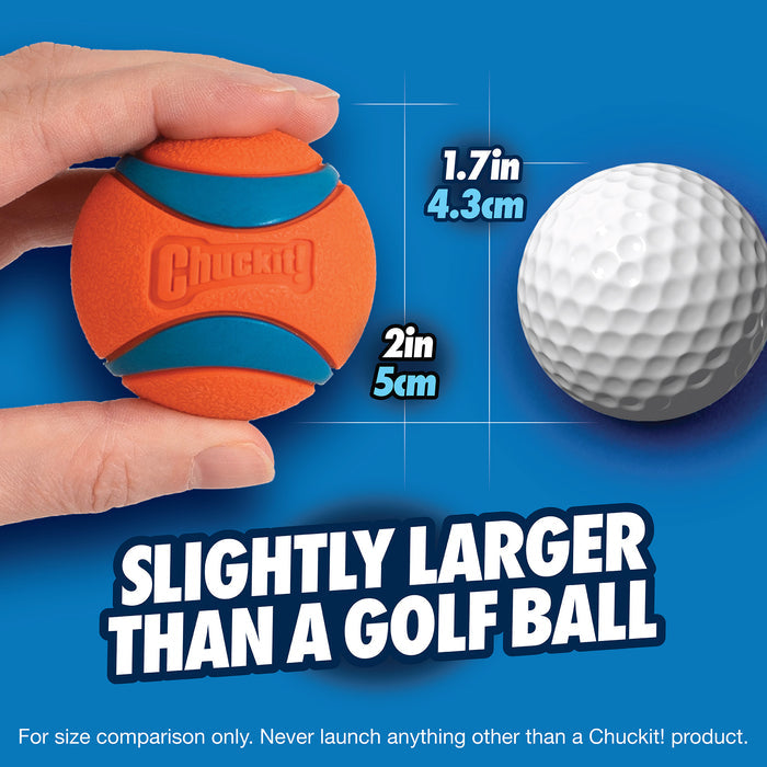 A hand holds a Chuckit! Ultra Ball Dog Toy by Chuckit! next to a 1.7-inch (4.3 cm) golf ball, highlighting that this durable 2-inch (5 cm) dog fetch ball is slightly larger than a standard golf ball.