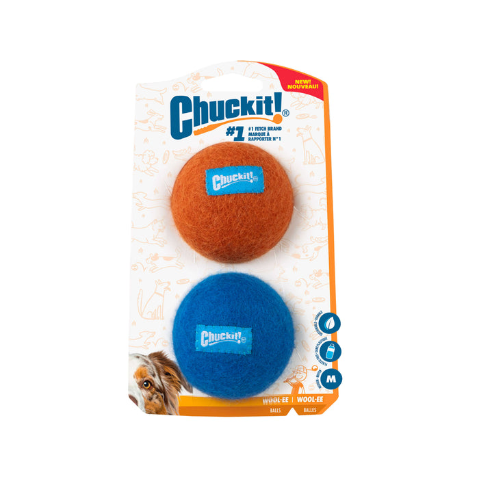 The Chuckit! Wool-ee Ball by Chuckit! is shown in its packaging, featuring one orange and one blue medium ball with a cartoon dog background. Made from natural wool, these eco-friendly dog toys offer safe play for pets.