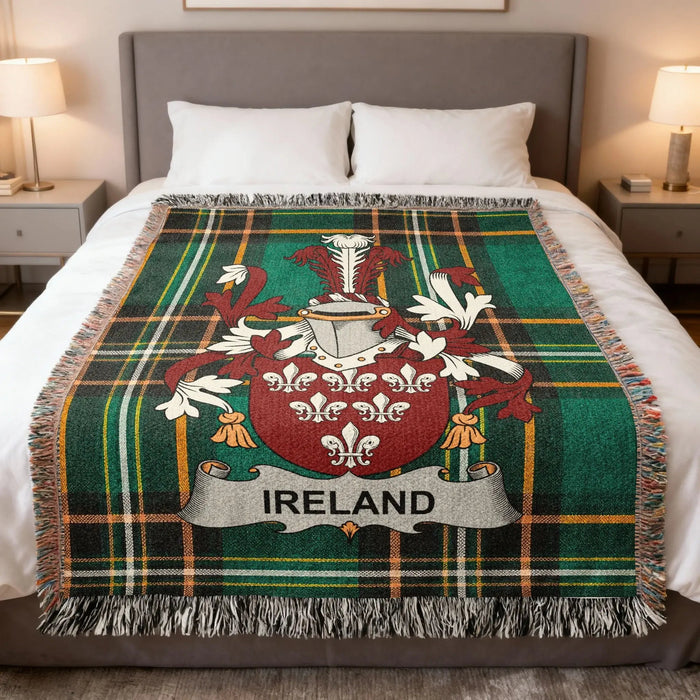 Irish family crest woven blanket with an IRELAND banner and green tartan design, shown on a bed