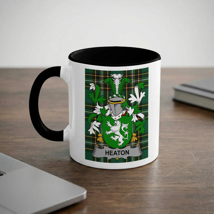 White mug with black rim featuring the Heaton family crest and name.