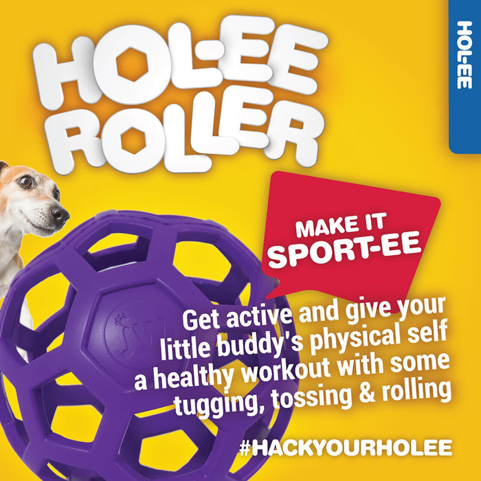 A JW Hol-ee Roller Dog Toy by JW Pet, in purple natural rubber, sits beside a small dog on yellow. Text encourages active play: MAKE IT SPORT-EE and #HACKYOURHOLEE.