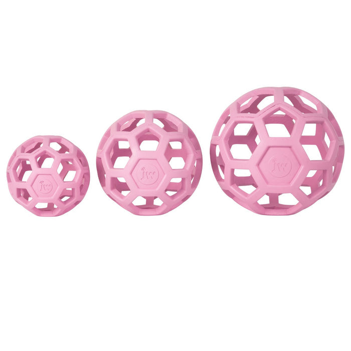 Three pink JW Hol-EE Roller Trend-EE toys from JW Pet are shown in a row. Each hollow ball features interconnected hexagons with the JW logo, ideal as a chew or puzzle toy for engaging your dog’s mind.
