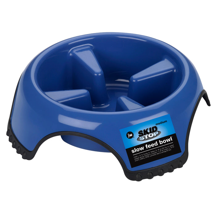 The JW Pet JW Skid Stop Slow Feed Bowl is a blue plastic bowl with raised ridges to slow fast eaters. It features a black rubber base to prevent slipping and "SKID STOP" labeling.