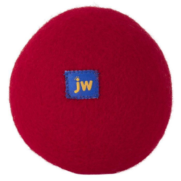 The JW Pet Wool-ee Ball is a red, oval eco-friendly dog toy made from natural wool, featuring a small blue patch with yellow "jw" letters at the center, shown against a white background.