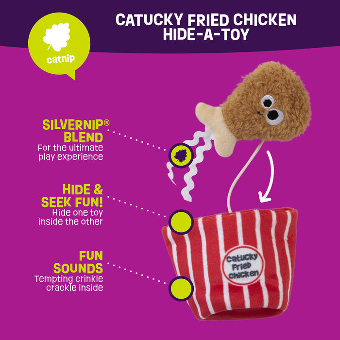 The Mad Cat Catucky Fried Chicken illustrated cat toy features a plush drumstick with eyes in a striped red and white bucket. It offers the Silvervine-infused Silvernip™ Blend, Hide & Seek Fun, and Fun Sounds for playful engagement, making it an ideal cat puzzle toy.