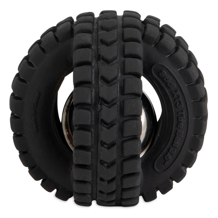 The Petqwerks Jingle X-Tire Ball dog toy has a black rubber tire-like design with grooves and treads. It features two connected tires with a visible silver jingle ball in between for extra fun.