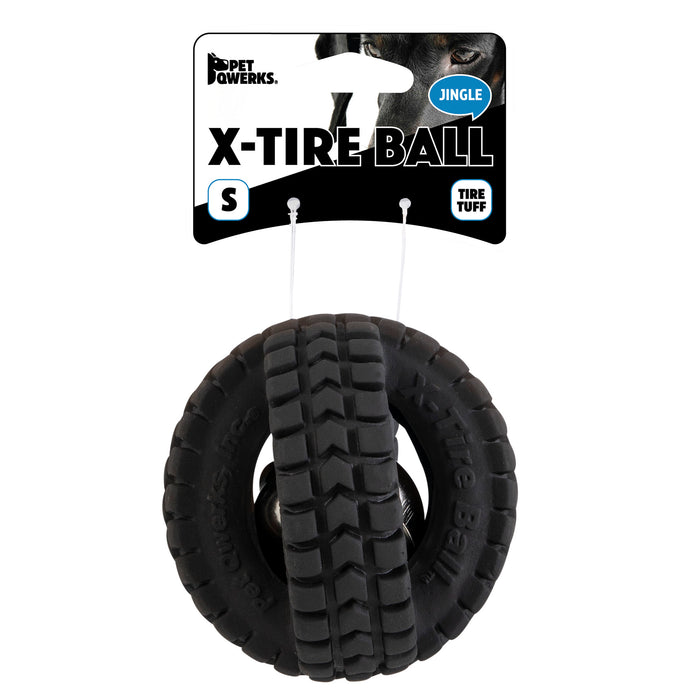 A black rubber dog toy, resembling two interlocked tires, is labeled Pet Qwerks Jingle X-Tire Ball. The packaging features the brand Petqwerks and describes it as a Tire Tuff jingle ball in size S.