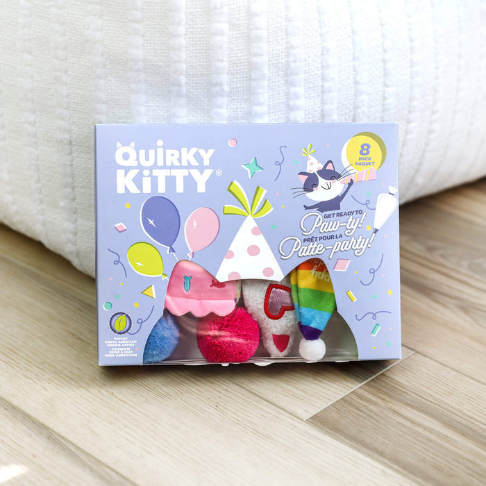 The Quirky Kitty Birthday Box 8pk – Birthday & Gotcha Day Cat Toy Gift Set by Quirky Kitty features colorful party toys in festive packaging with balloons and a cat in a party hat, perfect as a cat gift set.