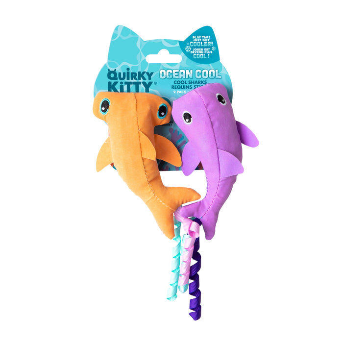 The Quirky Kitty Color Changing Shark 2pk features orange and purple plush shark catnip toys with big eyes and twisted tails, packaged in blue ocean-themed “Quirky Kitty Ocean Cool” graphics.