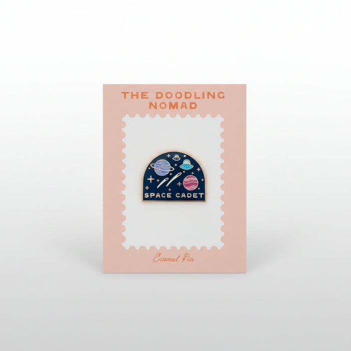 Enamel pin with planets and stars, in a black background, and the words "Space Cadet" in gold.